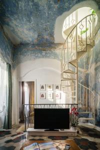 uma sala de estar com uma escada e um tecto azul em Domu Manca em Torpè