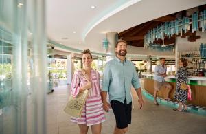 un homme et une femme se promenant dans un centre commercial dans l'établissement ROBINSON Cyprus, à Alaminos