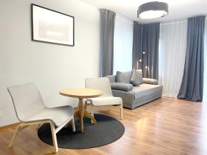 ein Wohnzimmer mit einem Sofa, einem Tisch und Stühlen in der Unterkunft 11 Gdynia Morska - Apartament Mieszkanie dla 5 osób in Gdynia