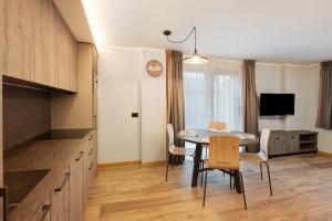 een keuken en eetkamer met een tafel en stoelen bij Sun Mountain Planet Suite House in Livigno