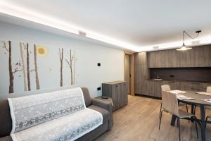 een woonkamer met een bank en een tafel bij Sun Mountain Planet Suite House in Livigno