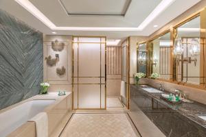 a bathroom with two sinks and a tub and a large mirror at Taj Exotica Resort & Spa, The Palm, Dubai in Dubai