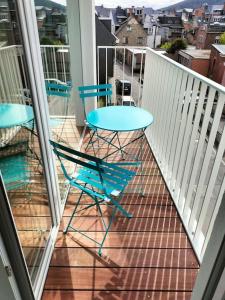 balcone con 2 sedie e un tavolo sopra di Superbe Appartement avec Parking a Malmedy