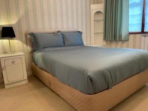 1 dormitorio con 1 cama grande, mesita de noche y ventana en Cheerful 3 bedroom house with off street parking, en Bromley