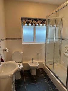 a bathroom with a toilet and a sink and a shower at Cheerful 3 bedroom house with off street parking in Bromley