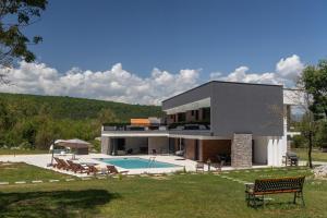 a large house with a swimming pool in front of it at NEW! Villa Nella Foresta with private 66sqm heated pool, Whirlpool, Tennis court, Gym, Billiards, 4 en-suite bedrooms in Radošić