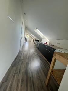 een lege kamer met een keuken en een houten vloer bij MZ Zimmervermietung 