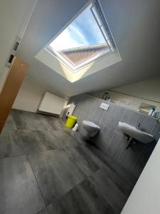 a bathroom with a skylight and a toilet and sink at MZ Zimmervermietung 
