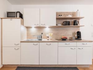 a kitchen with white cabinets and a counter at MYALPS Mühlhof in Oetz