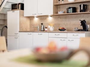 オエッツにあるMYALPS Mühlhofの白いキャビネットと食べ物を入れたキッチンが備わります。