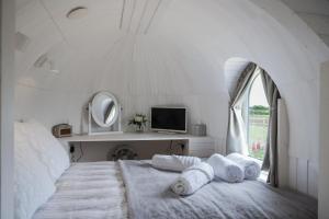 um quarto branco com uma cama grande e uma janela em “Whitekirk” Rock & Castle Escapes em Whitekirk