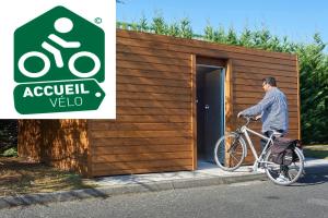 Un homme sur un vélo devant un bâtiment dans l'établissement Atena Bordeaux Sud Est Créon - Vélo Friendly, à Créon