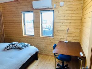 ein Schlafzimmer mit einem Bett und einem Schreibtisch mit einer Lampe in der Unterkunft BALLAD HOUSE / Vacation STAY 27536 in Yachimata
