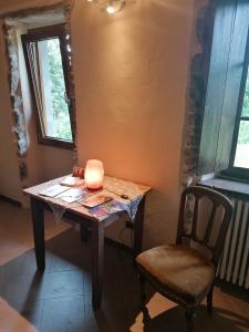 uma mesa com uma vela e uma cadeira num quarto em BeB LORTALLINO em Ameno