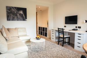 a living room with a white couch and a desk at Lancaster House Hotel in Lancaster