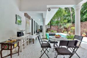 a living room with chairs and a table at StayVista at Vintage Hideaway Pet-Friendly Paradise with Private Pool in Porvorim