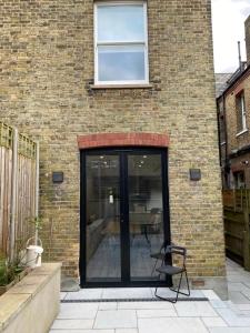 a brick building with a glass door on a patio at Stylish home in Streatham. in London