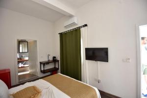 a bedroom with a bed and a green curtain at Benjamin pansiyon in Gümüşlük