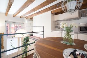 una cocina con una mesa de madera y un jarrón de flores en Romantic loft Porta Venezia MILAN, en Milán