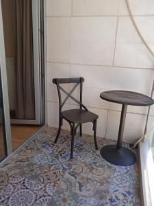 a table and a chair and a table and stool at BC Apartments in Tbilisi City