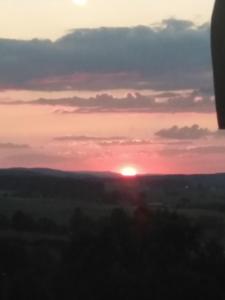 una puesta de sol sobre un campo con el sol en el cielo en Panayotovi Guest House, en Byala