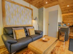 a living room with a leather couch and a wooden table at Barbondale in Carnforth