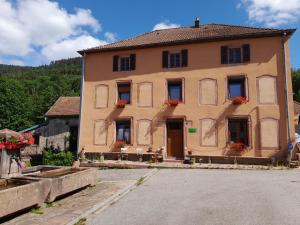 un edificio con cajas de flores en sus ventanas en La maison du vannier en Raon-lès-Leau