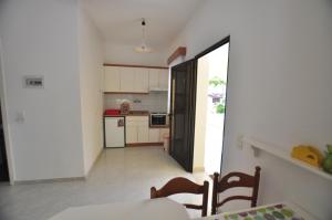 cocina y comedor con mesa y sillas en Antigoni Apartments, en Acharavi