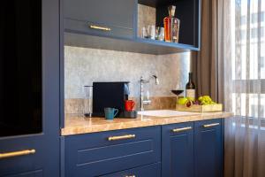 a kitchen with blue cabinets and a sink and a window at The David Story Boutique in Jerusalem