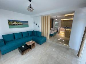 uma sala de estar com um sofá azul e uma cozinha em Apartments Pericic em Sutomore