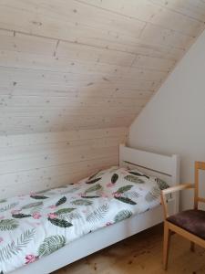 a bed in a room with a wooden ceiling at Zagroda nad Hańczą in Błaskowizna