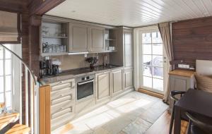a kitchen with white cabinets and a large window at Hafjell tømmerhytte 4B in Hafjell