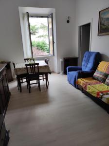 Fiuggiamo House في فيوجي: غرفة معيشة مع طاولة وأريكة زرقاء