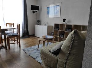 sala de estar con sofá y mesa en La Géla, studio cabine pieds de pistes, en Aragnouet