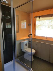 a bathroom with a toilet and a glass shower at TEIRABOA BASE CAMP in Arzúa