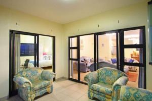 1 dormitorio y sala de estar con 2 sillas. en Knightsbridge 407 by HostAgents, en Ciudad del Cabo
