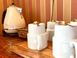 a group of white cups sitting on top of a wooden table at Hotel Hospitz in Savonlinna