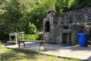 eine Steinmauer mit einer Bank neben einem Steinofen in der Unterkunft Rent House Orahovo in Virpazar
