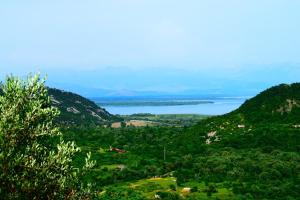 Elle offre une vue sur une vallée avec un lac et des montagnes. dans l'établissement Rent House Orahovo, à Virpazar