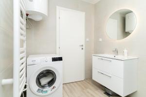a white laundry room with a washing machine and a sink at Bokarica Apartments in Gruda