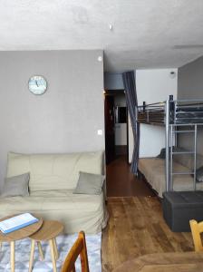 ein Wohnzimmer mit einem Sofa und einem Etagenbett in der Unterkunft La Géla, studio cabine pieds de pistes in Aragnouet