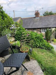 a garden with a table and chairs and a house at Annie’s Cottage in Llanrhaeadr-ym-Mochnant