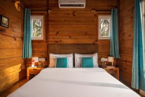 a bedroom with a bed and two windows at Mariners Bay Beach Resort in Arambol