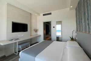 a bedroom with a bed and a desk and a tv at Hotel Rex in Livorno