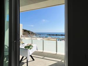 a table on a balcony with a view of the ocean at Hotel Rex in Livorno