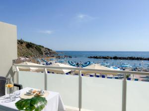 a table on a balcony with a view of the ocean at Hotel Rex in Livorno