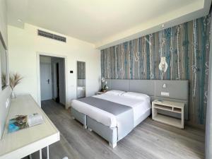 a bedroom with a large bed and a table at Hotel Rex in Livorno