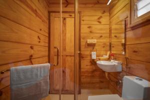 a bathroom with wooden walls and a sink and a shower at Mariners Bay Beach Resort in Arambol