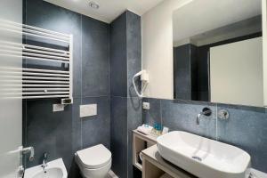 a bathroom with a sink and a toilet and a mirror at Hotel Rex in Livorno