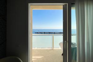 an open door to a view of the ocean at Hotel Rex in Livorno